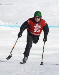 An adaptive skier uses a 3 track to ski